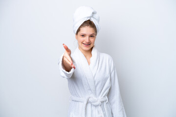 Teenager Russian girl in a bathrobe isolated on white background shaking hands for closing a good deal