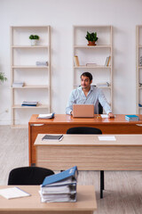 Young male employee sitting in the office