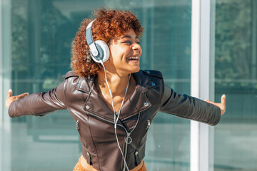 Naklejka premium girl with headphones on the street smiling