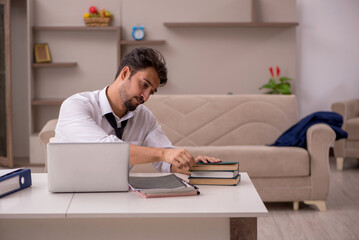 Fototapeta premium Young male employee working from home during pandemic