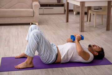 Young man doing sport exercises at home