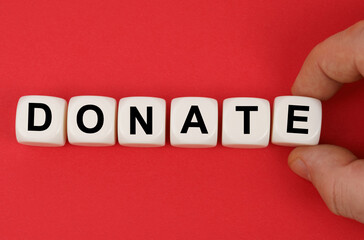 On the red surface, white cubes with the inscription - DONATE