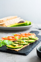 Appetizing sandwiches with avocado and tomatoes on grain bread. Vertical view. Selective focus