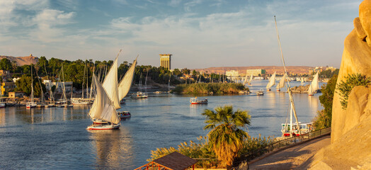 Beautiful panorama landscape with felucca boats on Nile river in Aswan at sunset, Egypt - obrazy, fototapety, plakaty