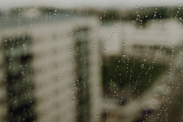 Raindrops on a window against some buildings