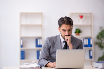 Fototapeta premium Young male employee working in the office