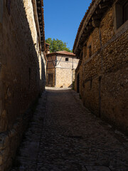 Vistas de una calle con casas de arquitectura medieval con decoración de madera,  en el pueblo de Calatañazor en España, província de Soria, en el verano de 2021