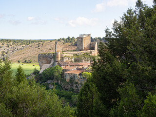 Fototapeta na wymiar Vistas de las ruinas del castillo y la muralla de Calatañazor rodeado de naturaleza verde, en Soria España, verano de 2021