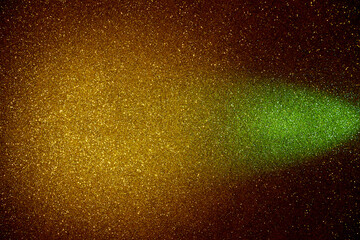 On a golden background in fine grain a wide beam of green light