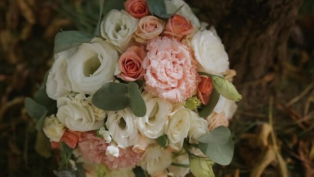 Exquisite elegant bouquet for a festive event. The flower arrangement is created by a florist from flowers of eustoma, roses, pink carnation and eucalyptus leaves. A bunch of flowers in nature