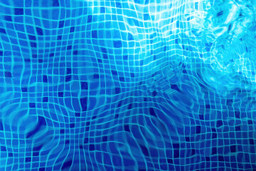 Sun reflection on the blue clear water ripples of pool with tile bottom. Bottom of the pool water texture.