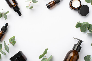 Natural cosmetics concept. Top view photo of glass bottles cream jars and eucalyptus leaves on...