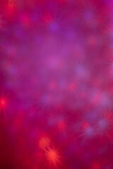 Multicolored festive background with bokeh stars.