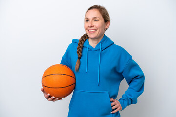 Young caucasian woman playing basketball isolated on white background posing with arms at hip and smiling