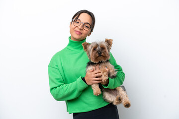 Young hispanic woman holding a dog isolated on white background with happy expression