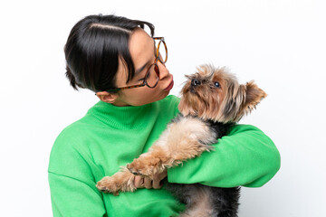 Young hispanic woman holding a dog isolated on white background