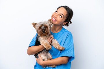 Young veterinarian woman with dog isolated on white background looking up while smiling