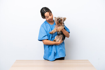 Young veterinarian woman with dog on a table isolated on white background with sad expression