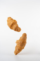 flying fresh croissants on a white background
