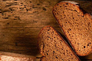 Bread, traditional homemade bread cut into slices on a rustic wooden background, close-up.