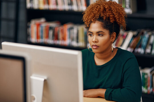 Prepping for her final exams. High angle shot of a young female university student studying in the library.