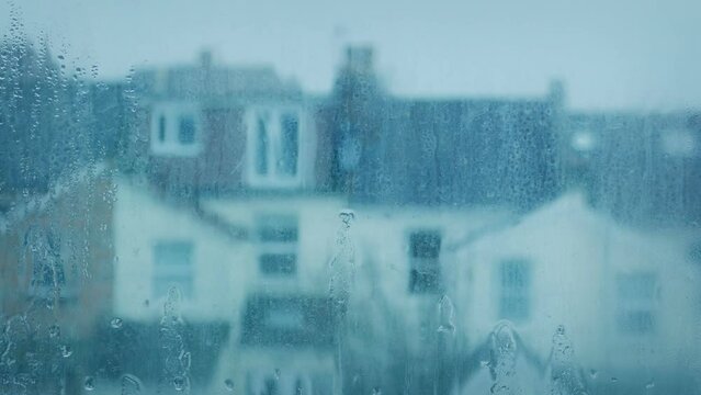 Rain Hitting Window With Houses Out Of Focus Behind