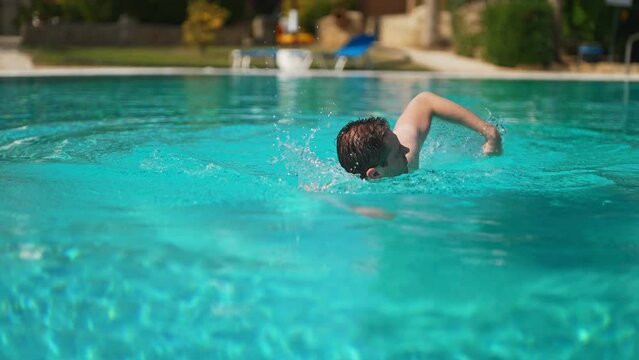 Man swimming in outdoor swimming pool.