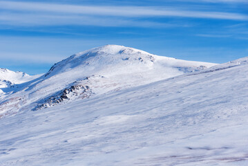 Fototapeta na wymiar Summit of Mulhacen in winter, all covered by a blanket of snow, seen from the southern slope.