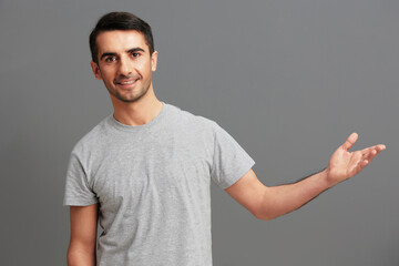 handsome man casual wear gray t-shirt fun hand gesture Gray background