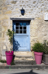 Fototapeta na wymiar Wooden blue door in a stone wall in Montrésor, Loire Valley, France