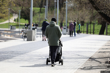 Tata z dzieckiem w wozku na spacerze w mieście.  © FotoDax