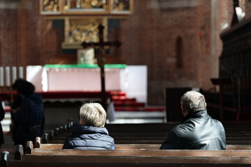 Fototapeta Para ludzi modli się w świętym kościele w skupieniu podczas świąt obraz
