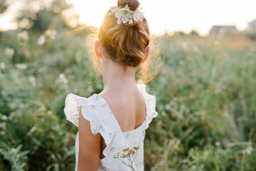 Fototapeta na wymiar Happy little girl in the field of Queen Anne's Lace flower