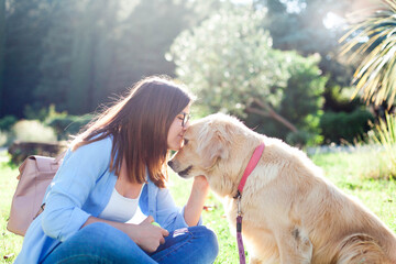 Pet owner kissing beautiful dog. Happy woman and labrador retriever