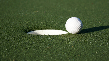 Close up of golf ball next to the hole - just missed.