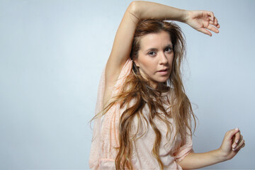 Naklejka premium Young hispanic woman rising one arm on head and looking at camera isolated on grey background. Human emotions concept. Copy space.
