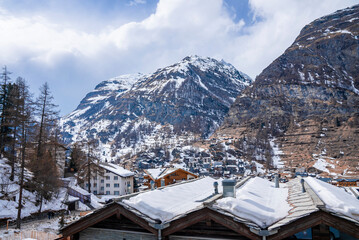 Scenic view of snow covered houses and mountain range against sky during winter