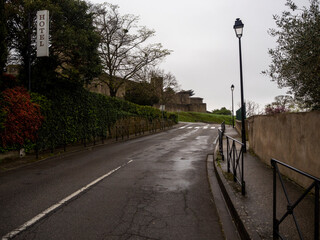 calle mojada por la lluvia, el cielo gris, y el cartel de un hotel