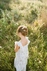 Fototapeta na wymiar Happy little girl in the field of Queen Anne's Lace flower