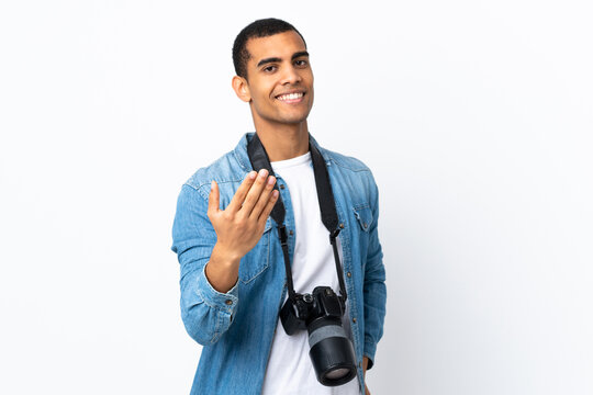 Young African American photographer man over isolated white background inviting to come
