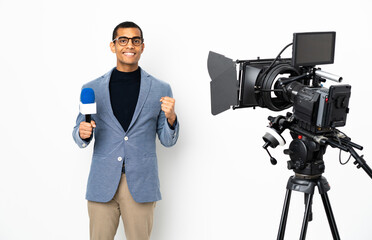 Reporter African American man holding a microphone and reporting news over isolated white background celebrating a victory in winner position