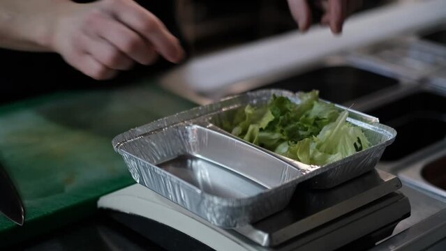 Food delivery in the restaurant. The chef prepares food in the restaurant and packs it. Panna cotta and vegetable salad in a plastic disposable containers