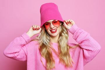 Cool cheerful girl with bright red lips wears modern knitted cap