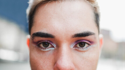 Gay man wearing makeup on looking at camera outdoor - LGBTQ drag queen, non-binary concept