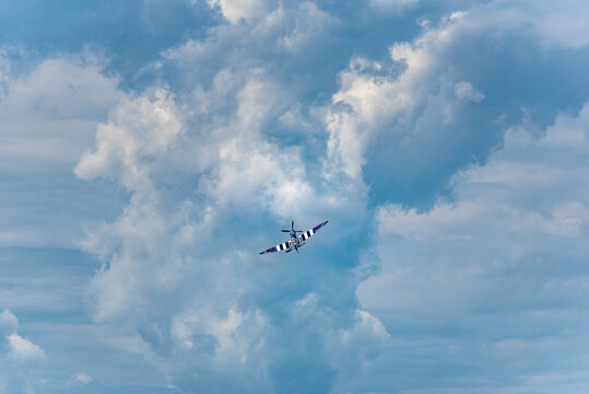 Moose Jaw, Saskatchewan, Canada- July 7, 2019: Supermarine Spitfire Mk IX flying into storm clouds at the Saskatchewan Airshow