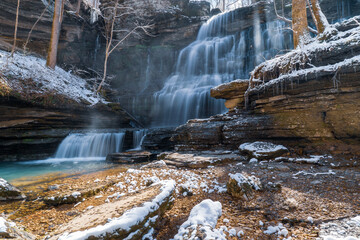 Beautiful Machine Falls waterfall with snow covered rocks on a sunny cold winter day near Tullahoma Tennessee.