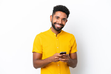 Young Brazilian man isolated on white background sending a message with the mobile