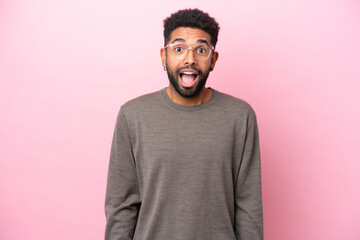 Young Brazilian man isolated on pink background with surprise facial expression