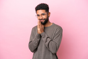 Young Brazilian man isolated on pink background keeps palm together. Person asks for something