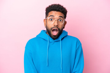 Young Brazilian man isolated on pink background With glasses and surprised expression